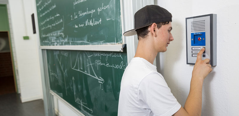 Schüler bedient Sprechstelle